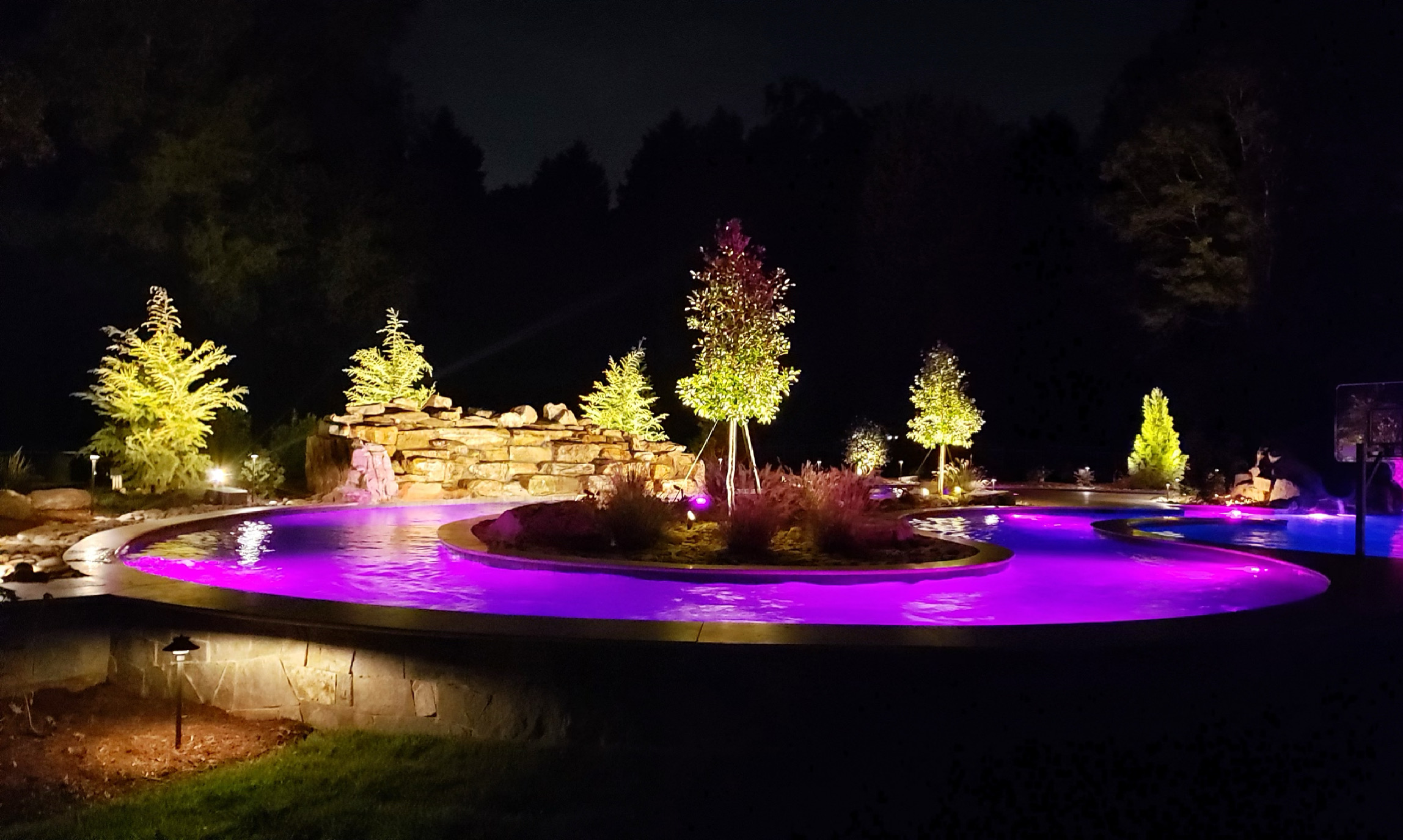 LED lighting around a water feature at night, purple and white lights